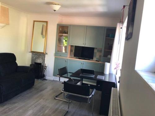 a living room with a couch and a table with chairs at Bright & spacious first floor apartment Cambridge in Chesterton