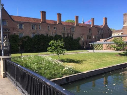 a large building with a pond in front of it at Bright & spacious first floor apartment Cambridge in Chesterton