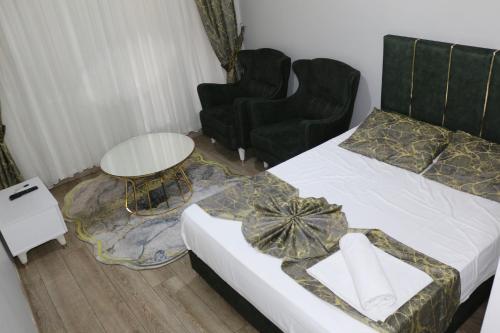 a bedroom with a bed and two chairs and a table at The Pashaam Suit in Istanbul