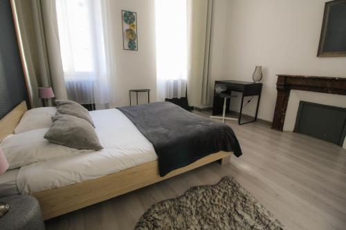 a bedroom with a large bed and a fireplace at Residence Pasteur Angouleme in Angoulême