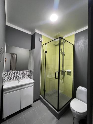 a bathroom with a glass shower and a toilet at Apart Hotel Bishkek in Bishkek