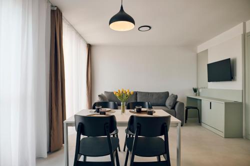 a dining room with a table and chairs and a couch at Malinska Green Apartments in Malinska