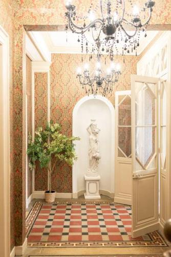 un couloir avec un lustre et une statue. dans l'établissement Immeuble L'Aristocrate - Le Boho- Bd Carnot, à Angers