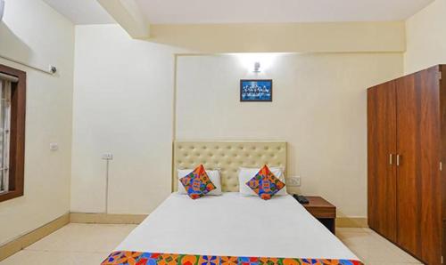 a bedroom with a bed and a wooden cabinet at FabHotel Triple Tree in Bhubaneshwar