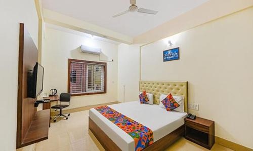 Schlafzimmer mit einem Bett, einem Schreibtisch und einem TV in der Unterkunft FabHotel Triple Tree in Bhubaneshwar