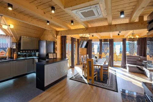 eine Küche und ein Wohnzimmer mit einem Tisch und Stühlen in der Unterkunft Domki Panorama Tatry Wellness sauna, jacuzzi, kominek in Kościelisko