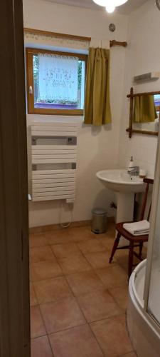 een badkamer met een wastafel en een tv aan de muur bij Gîte Bulle de Miel in Berru