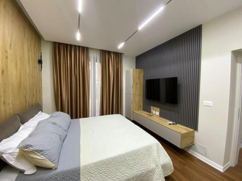 um quarto com uma cama e uma televisão de ecrã plano em Arkle Apartment 6 em Tirana