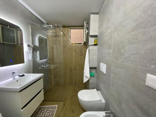 uma casa de banho com um WC branco e um lavatório. em Arkle Apartment 6 em Tirana