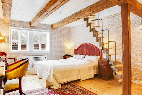 a bedroom with a large bed and a staircase at Anno 1793 Sekelgården in Ystad