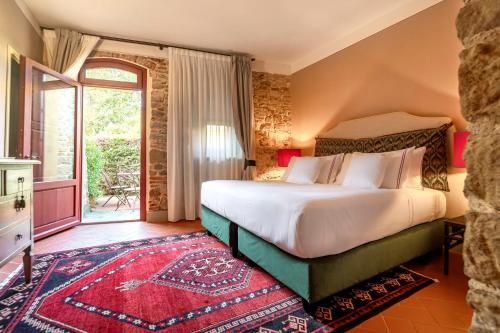 a bedroom with a bed and a large window at Tenuta di Artimino member of Meliá Collection Wine Resort in Artimino