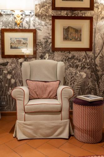 a chair with a pillow in a room with wallpaper at Tenuta di Artimino member of Meliá Collection Wine Resort in Artimino