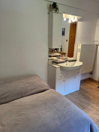 a white bathroom with a sink and a mirror at Haus Edelweiss in Obertraun