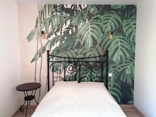 um quarto com uma cama com uma parede de plantas em La Source, location saisonnière proche Cognac em Saint-André