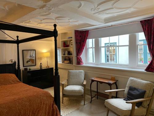 1 dormitorio con 1 cama, 2 sillas y mesa en The Totnes Guest House. Upstairs at Zappa's, en Totnes