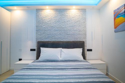 1 dormitorio con cama y pared de ladrillo en Blue Island - Luxury House, en Olbia