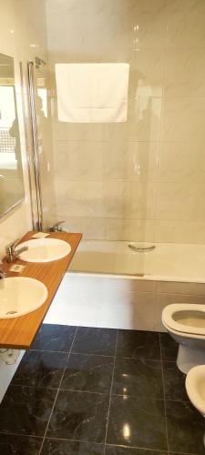a bathroom with two sinks and a tub and two toilets at Estudios Ermitabarri in Zeberio