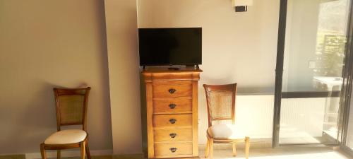 a tv sitting on top of a dresser with two chairs at Estudios Ermitabarri in Zeberio