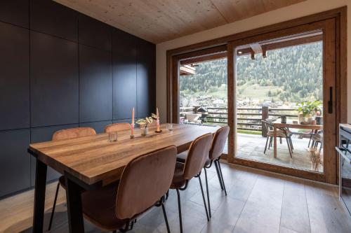 a dining room with a large wooden table and chairs at La Ruinette - Modern 2 Bed, Close To The Lift in Le Châble