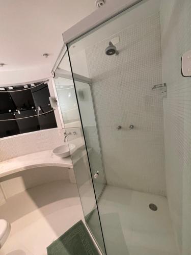 uma casa de banho com uma cabina de duche em vidro e um WC. em Acomodações do Tio Will - 2 no Guarujá