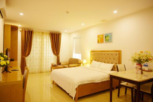 um quarto com uma cama, uma secretária e uma mesa em GEM Apartment & Hotel em An Khê