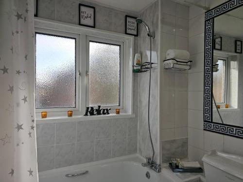 a bathroom with a tub and a shower curtain at Home in Beckton. Docklands. London City Airport. in London