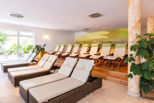 a room with chairs and a table and a painting at Best Western Plus Parkhotel Maximilian Ottobeuren in Ottobeuren