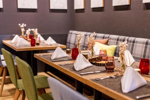a dining room with two tables with napkins on them at Best Western Plus Parkhotel Maximilian Ottobeuren in Ottobeuren