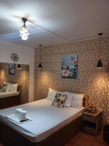 een slaapkamer met een groot bed met witte lakens bij DJCI APARTELLE in Cabanatuan