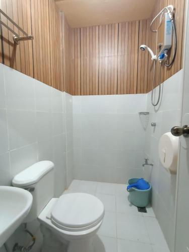 a white bathroom with a toilet and a sink at DJCI APARTELLE in Cabanatuan