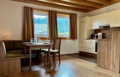 eine Küche und ein Esszimmer mit einem Tisch und Stühlen in der Unterkunft Landhotel - Apartments Bauer in Hintergöriach