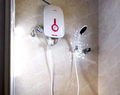 una ducha con secador de pelo pegada a la pared en Baladad Transient House, en San Fernando