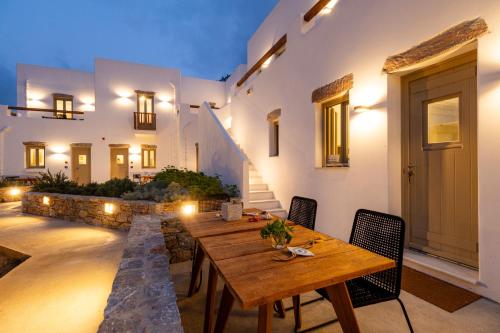a patio with a wooden table and chairs at Soil Amorgos in Katapola