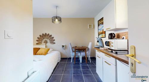 une chambre avec un lit et une cuisine avec une table dans l'établissement Pouvillon - 10min du Zenith - Théâtre - Musée, à Toulouse