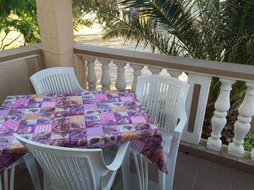 een tafel en stoelen op een balkon met een tafel en een tafelkleed bij Apartments Dobrana in Novalja