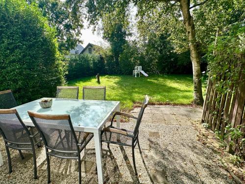 a table with chairs and a bird sitting on it at Noordzeehuisje in Sint Maartensvlotbrug