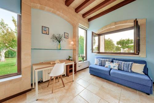 een woonkamer met een blauwe bank en een tafel bij HelloApulia Family Villa with Pool, Lush Garden & BBQ - Near the Beache in Savelletri di Fasano