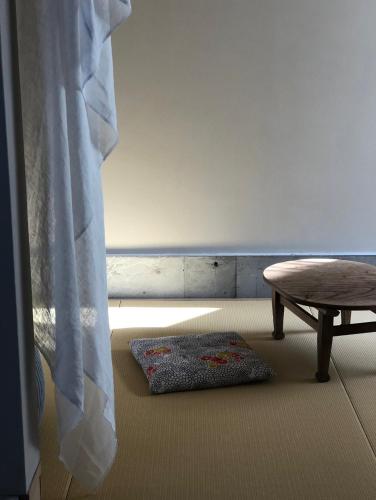 a room with a table and a rug on the floor at Nisainoyuyado Asahiya in Beppu