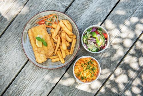 a plate of food with french fries and a salad at Maszoperia Sun4hel Kite & Wind & Surf in Jastarnia