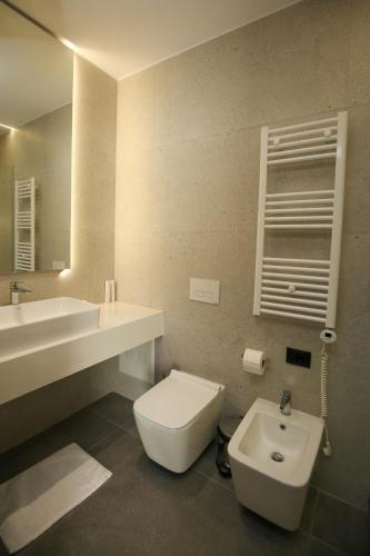 a bathroom with a white toilet and a sink at Charm Hotel in Vlorë