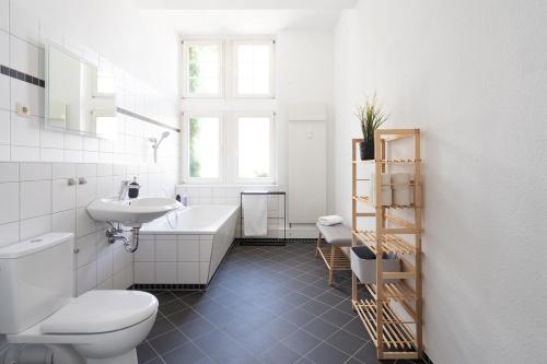 a bathroom with a sink and a tub and a toilet at Schloss - Apartments an der Uni - Klinik in Dresden