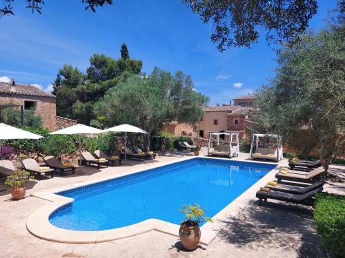 una piscina en un patio con sillas y sombrillas en Boutique Hotel Sa Galera, en Cas Concos