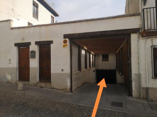 a building with an open door with an orange arrow at Casa el "Tablao de las Almendras" in Granada