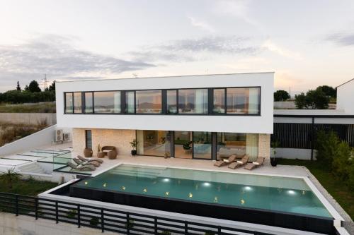 a house with a swimming pool in front of it at Villa Aurum ZadarVillas in Zadar