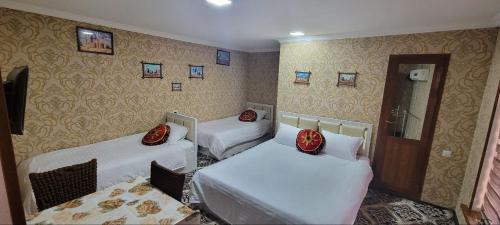 a room with three beds and a mirror at Imran&Bek in Samarkand