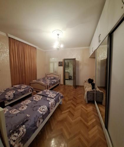 a room with three beds and a mirror at Kutaisi City Heart Apartment in Kutaisi