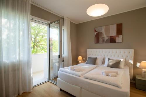 Casa DP في كونيليانو: غرفة نوم بسرير ابيض ونافذة كبيرة