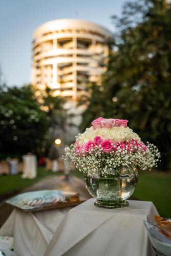 a vase filled with flowers sitting on a table at Taj Wellington Mews, Mumbai in Mumbai