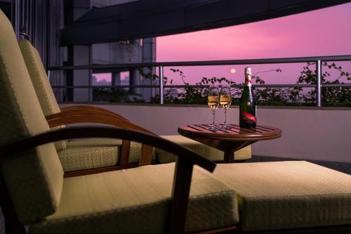 a bottle of wine and two glasses on a table at Taj Wellington Mews, Mumbai in Mumbai