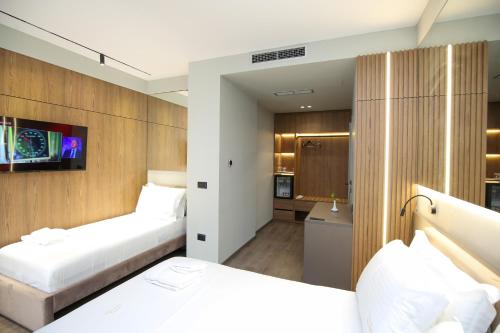 a hotel room with two beds and a bathroom at Charm Hotel in Vlorë